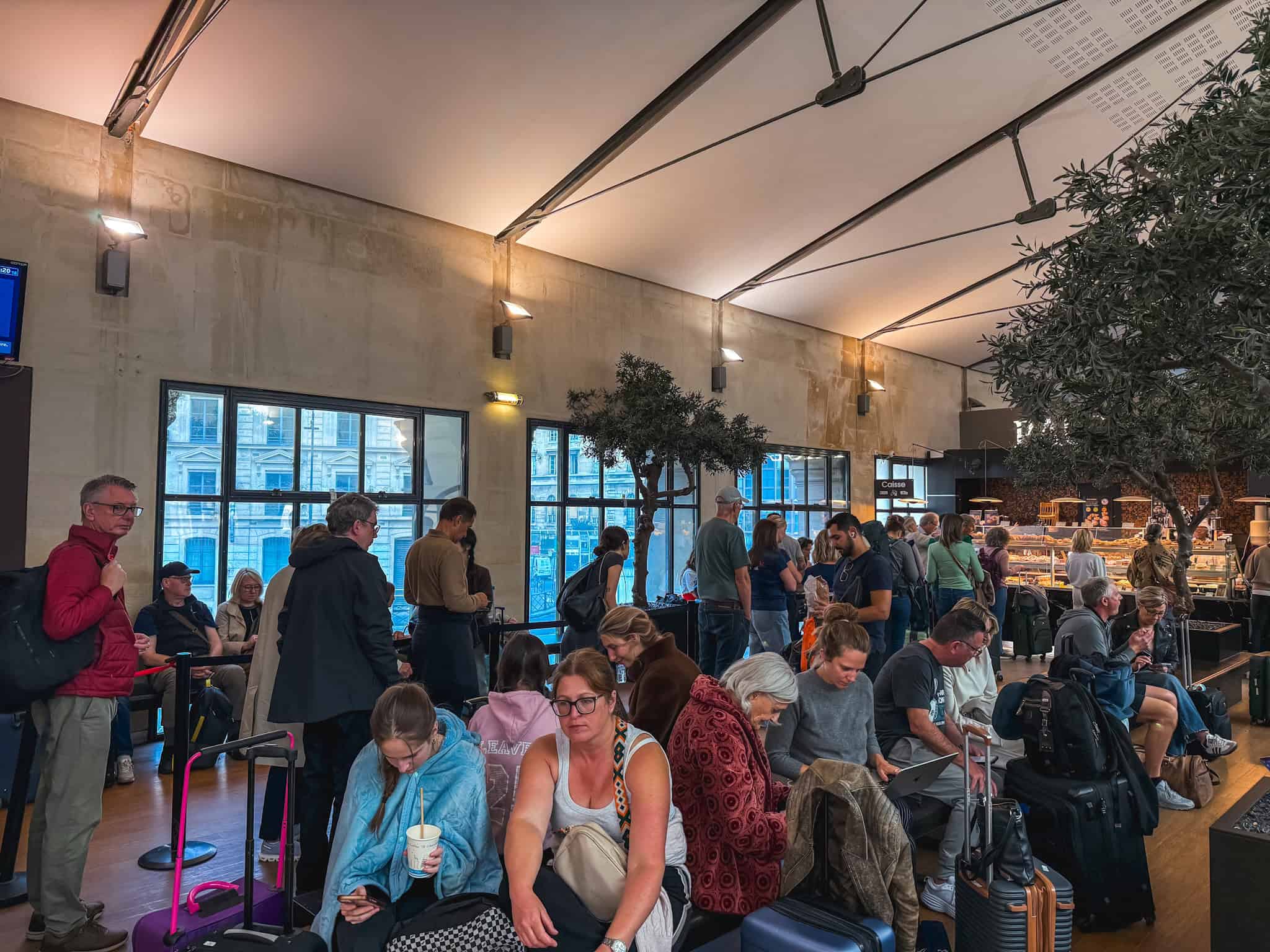 Crowded Eurostar passenger lounge at Gare du Nord filled with travelers and luggage waiting to board the train from paris to london