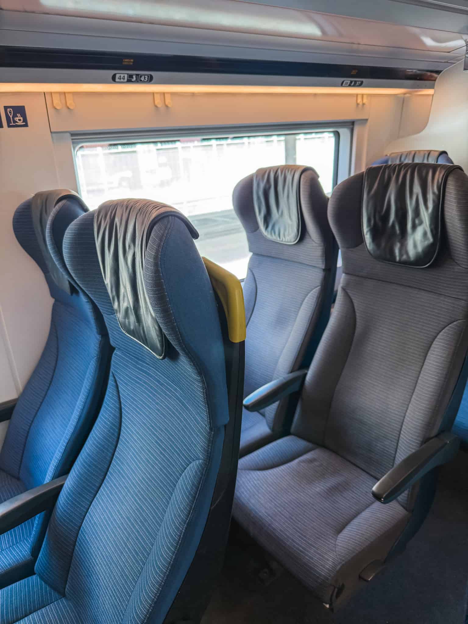 Comfortable blue reclining seats with headrests inside a Eurostar standard class cabin offering a relaxing cross-Channel journey from Paris
