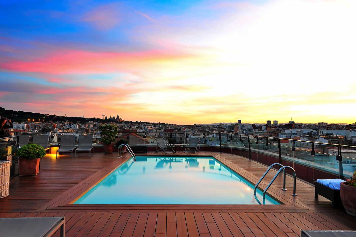 Rooftop swimming pool at sunset in Barcelona with panoramic city skyline and Montjuïc views — best rooftop hotels in Barcelona Spain
