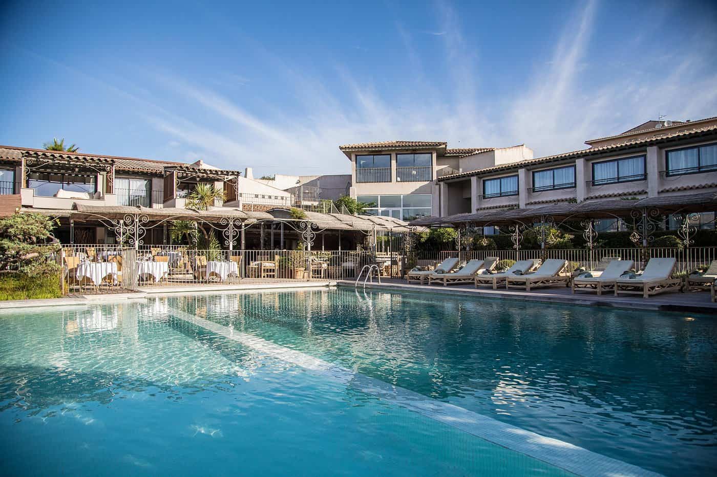 Outdoor swimming pool and alfresco restaurant terrace at Hotel Roi Théodore spa, Corsica — luxury Mediterranean hotel pool
