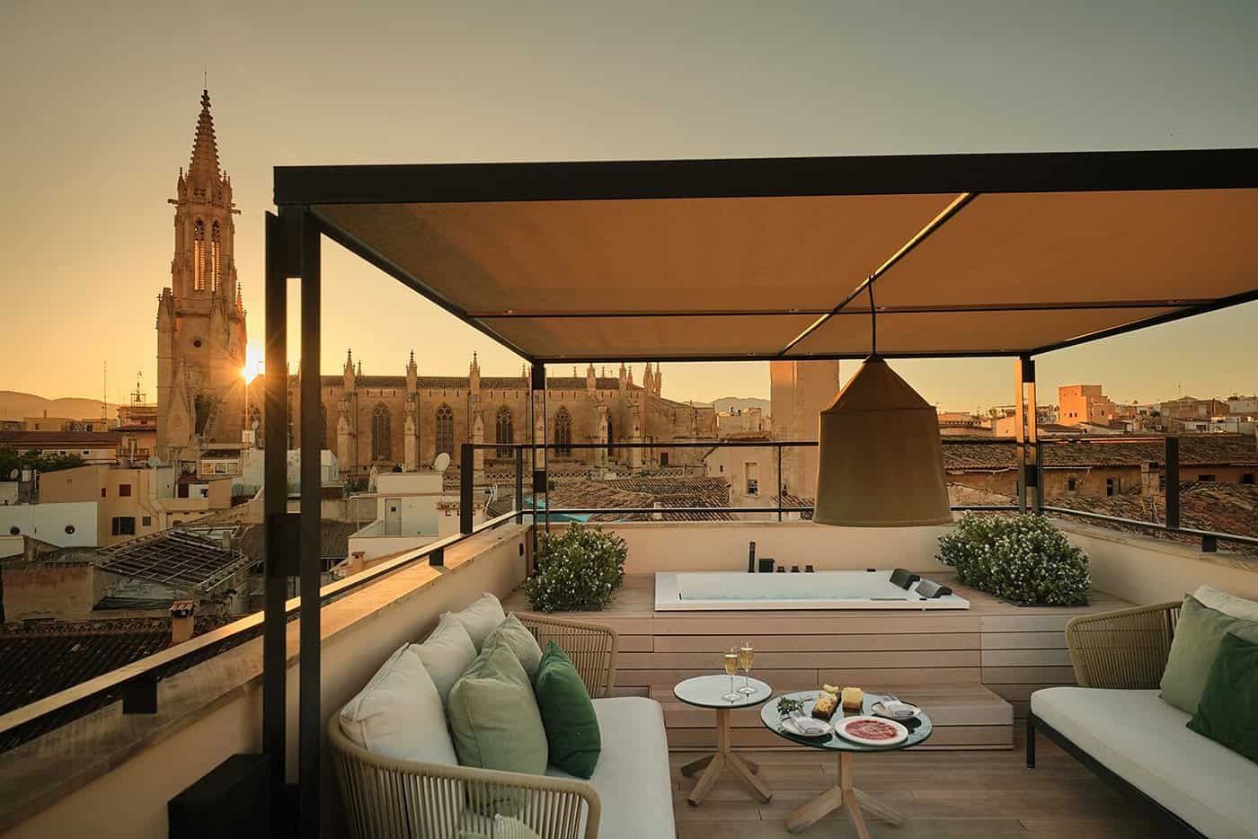 Luxury hotel rooftop terrace with jacuzzi at golden hour overlooking Palma Cathedral, Mallorca — where to stay in Mallorca Spain