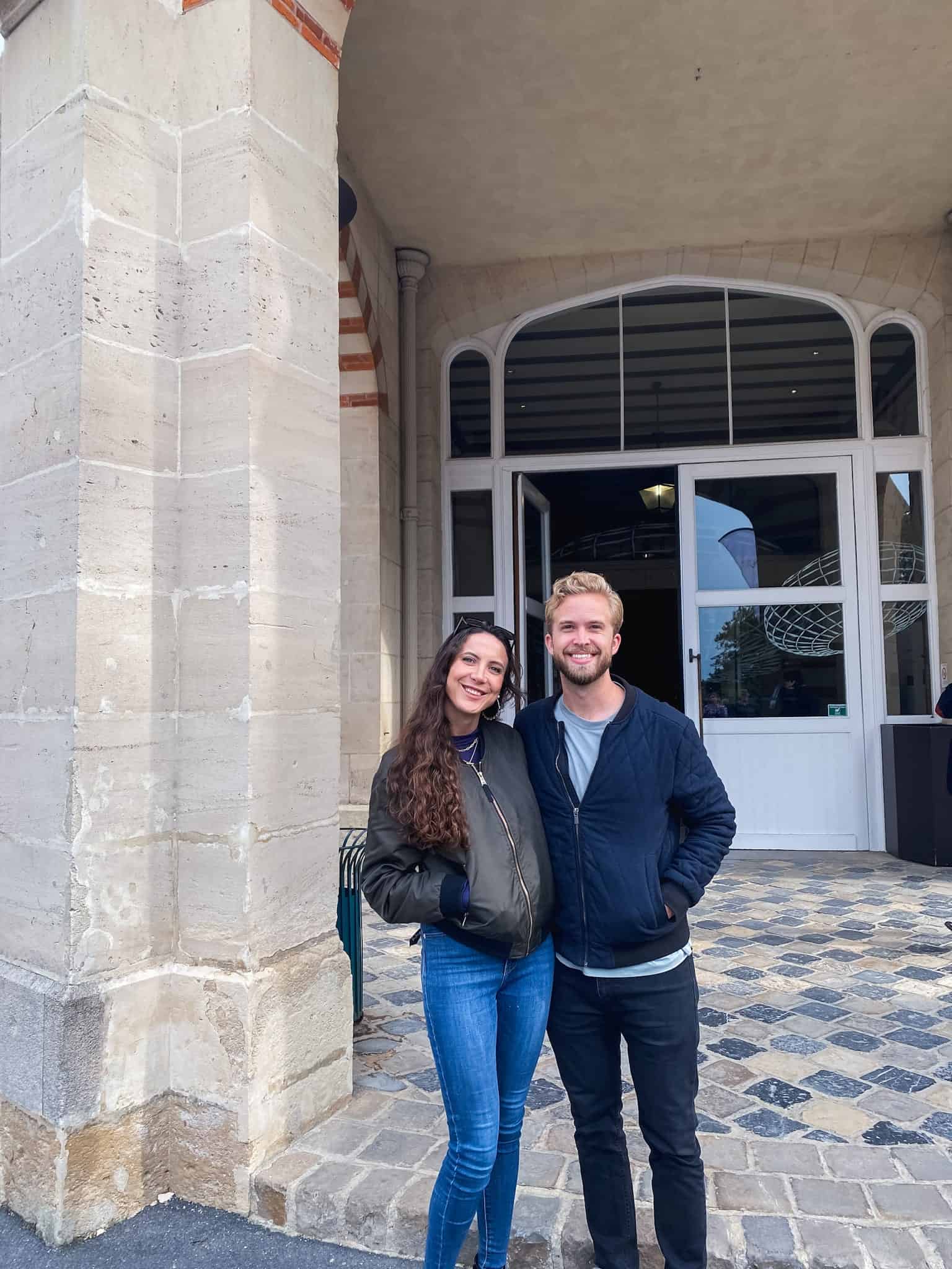 Couple standing outside champagne house entrance on day trip to visit Champagne from Paris
