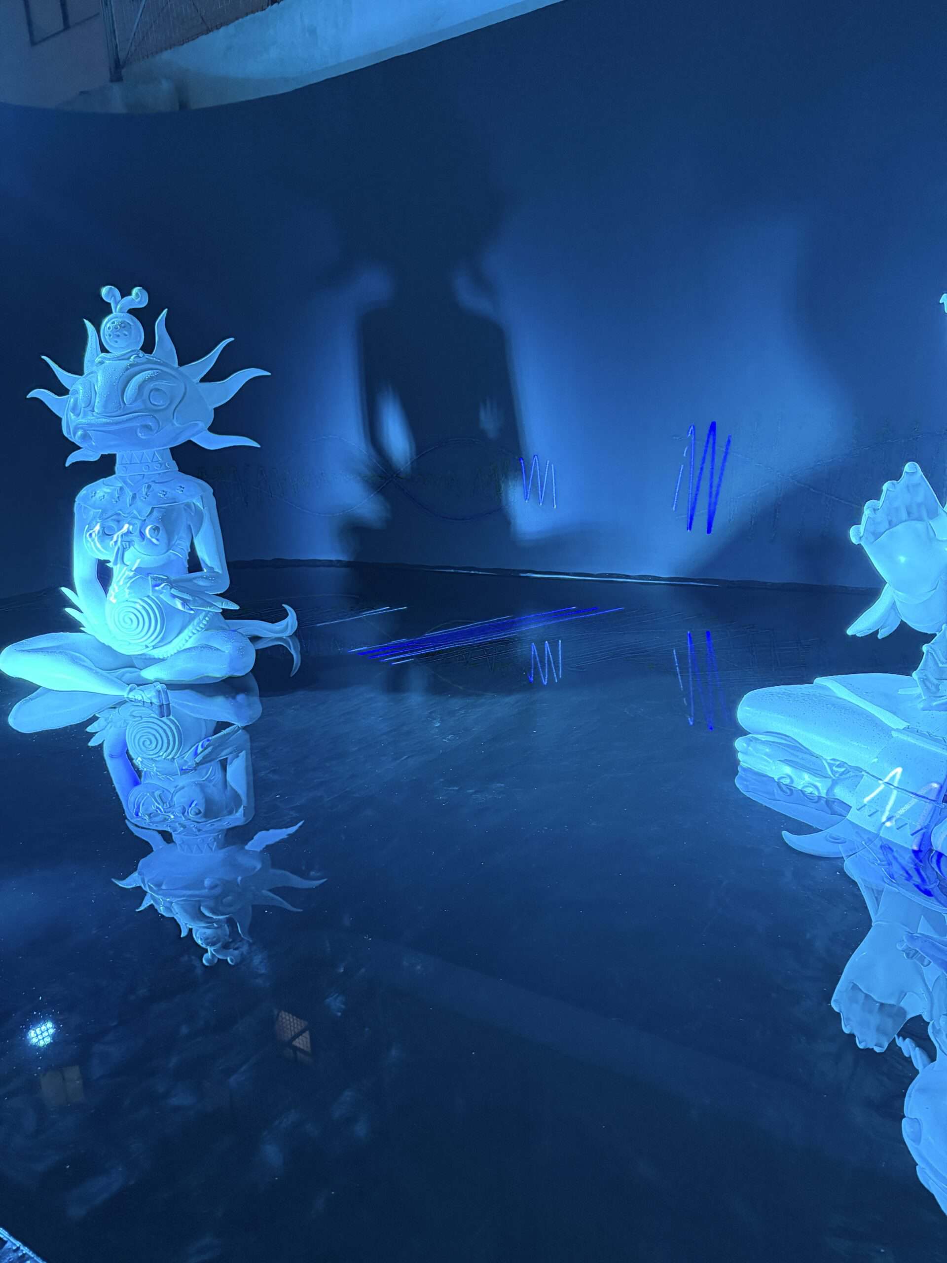 blue light over water statues in mexico city art week event