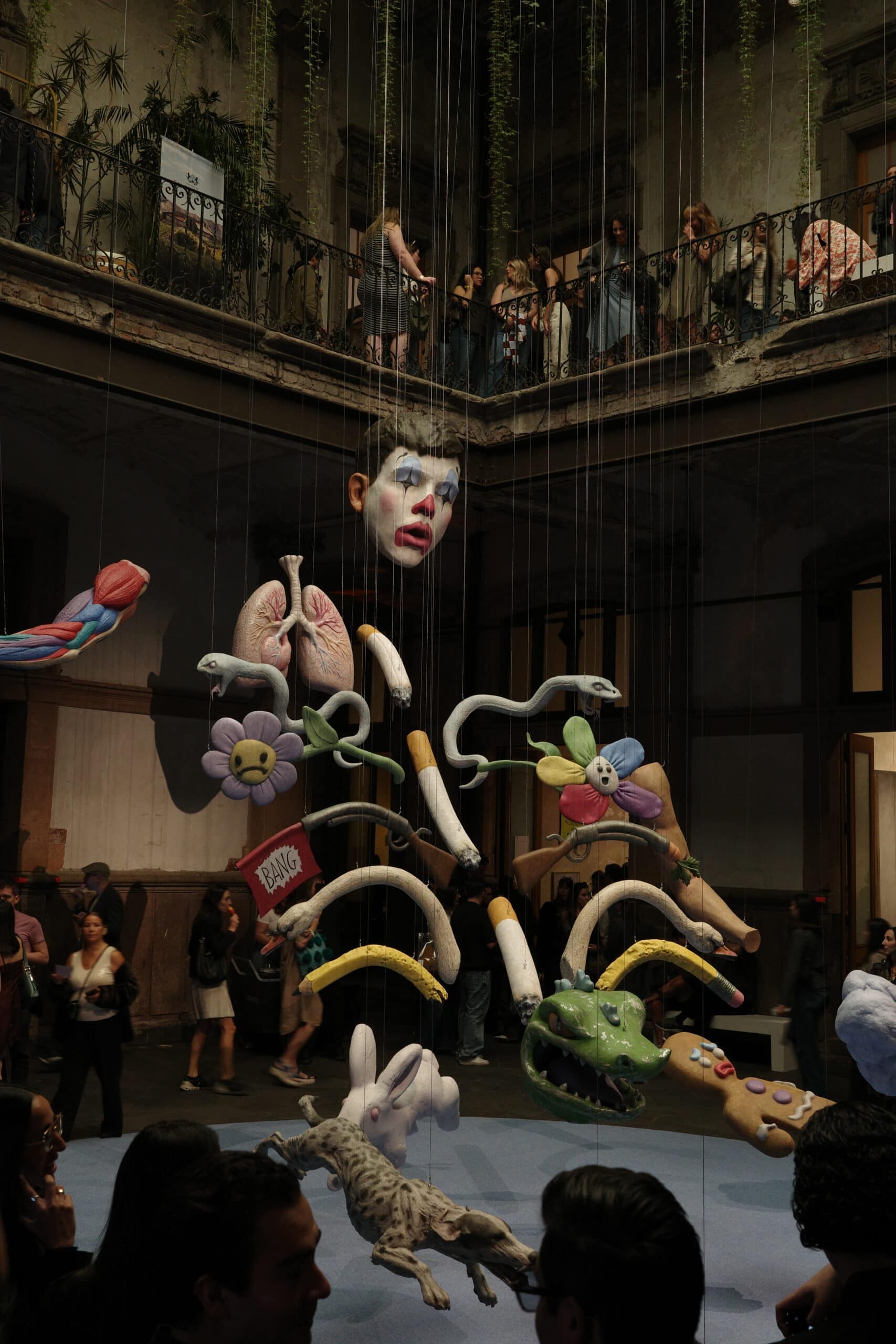 Large-scale suspended puppet sculpture with anatomical elements at art week Mexico City exhibition hall Salon Acme