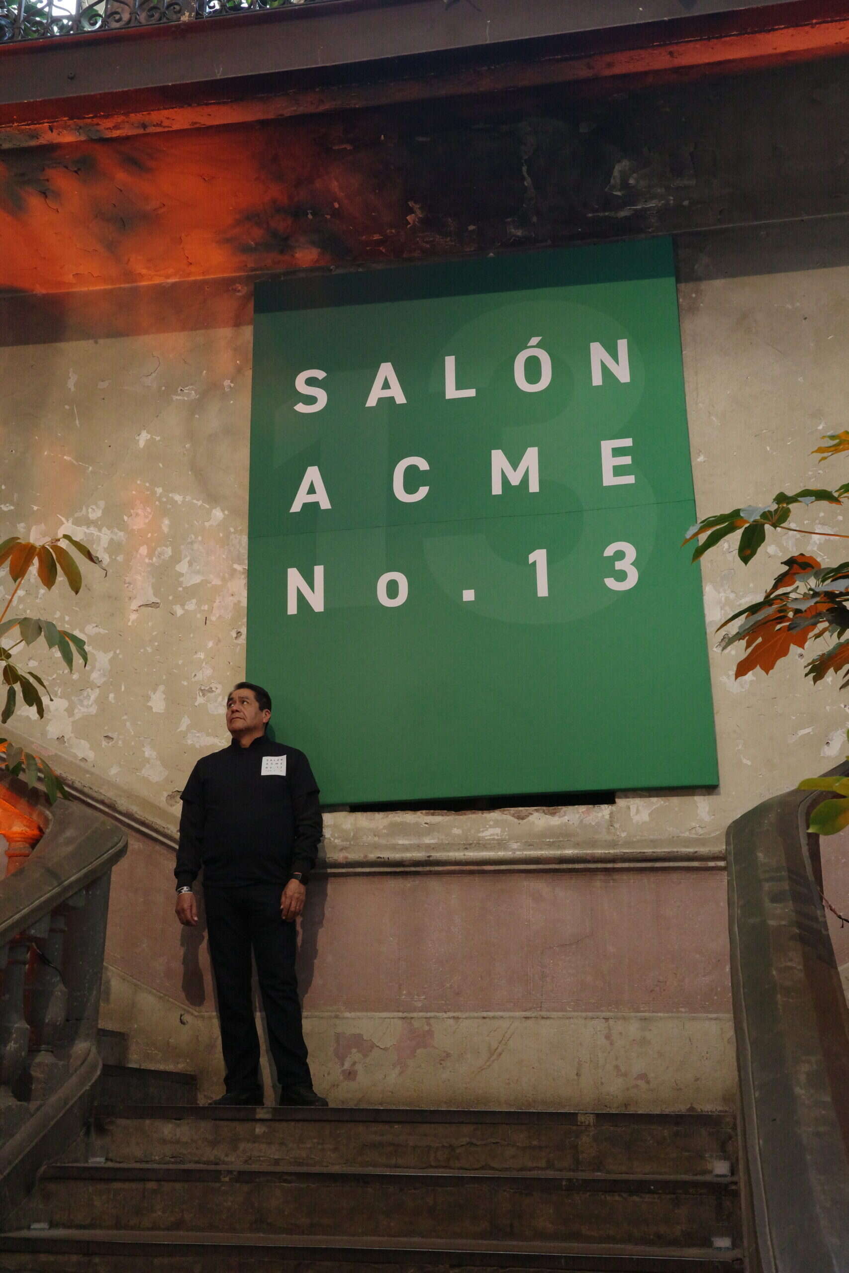 Salon ACME No. 13 green entrance signage with security guard at art week Mexico City venue
