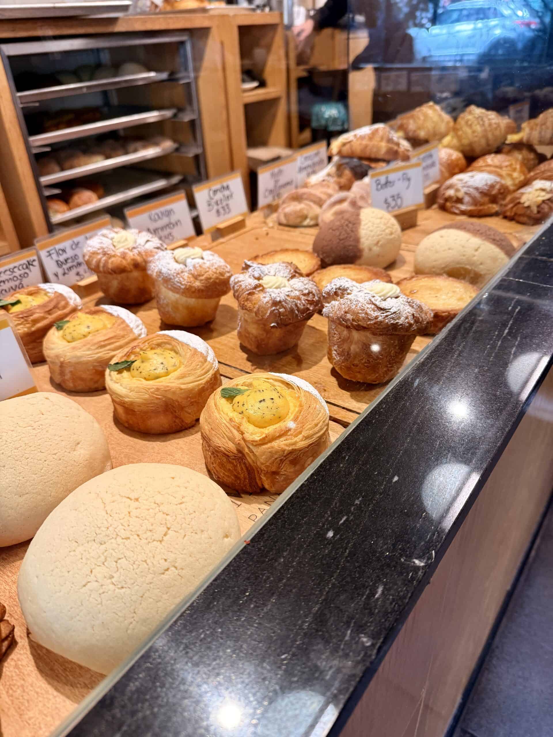 Artisan pastries and croissants display at bakery counter during art events Mexico City