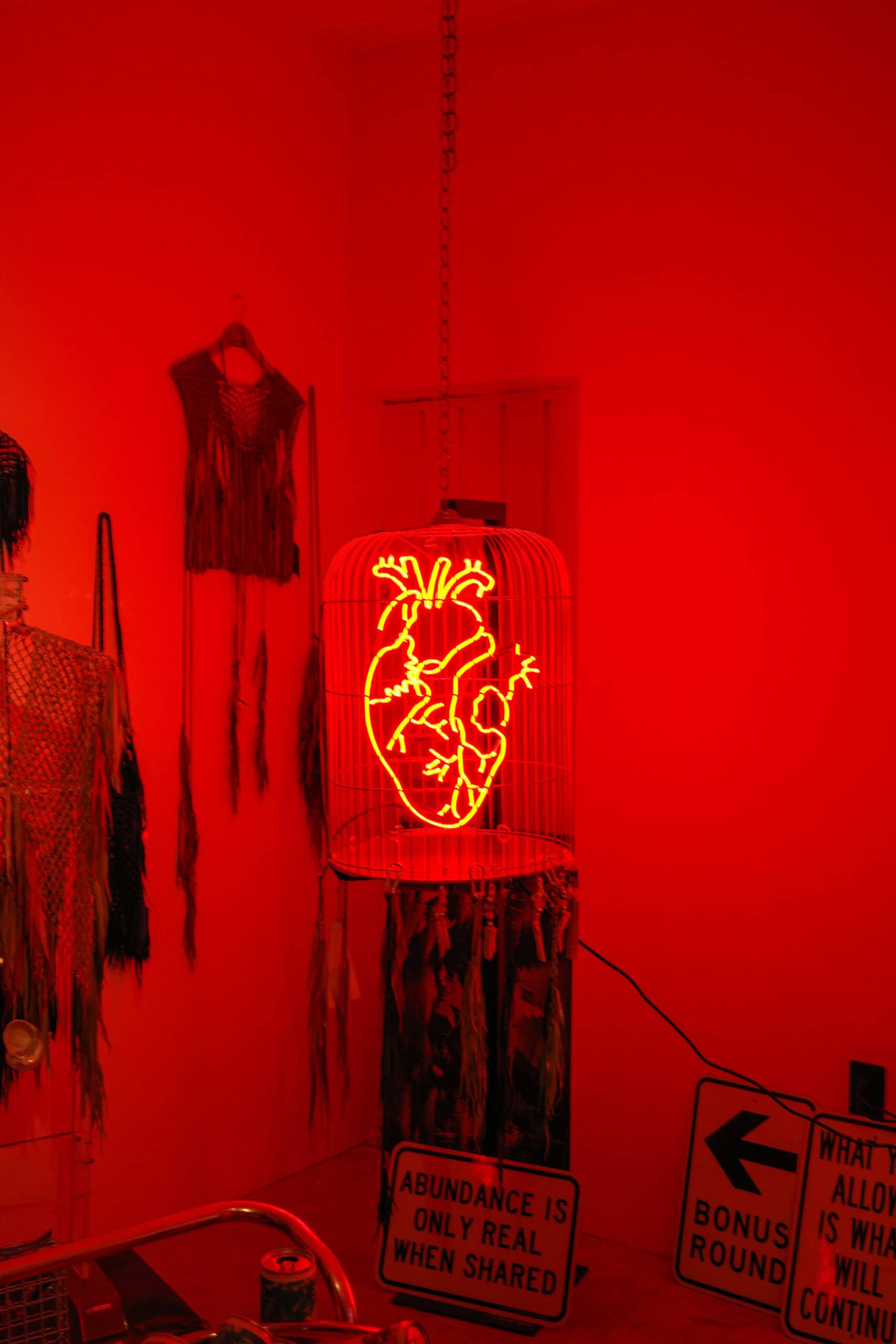 neon heart in red cage