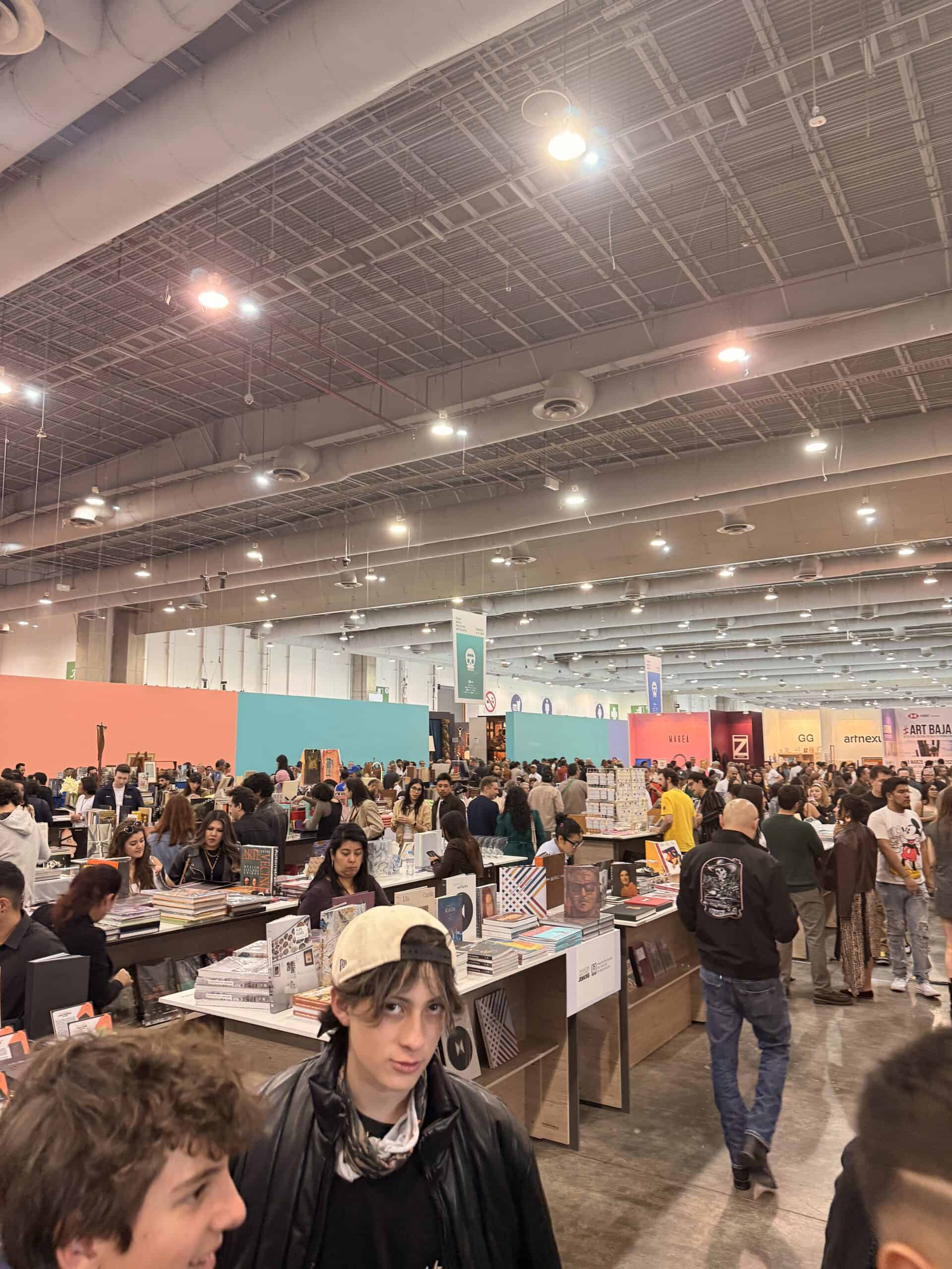 Crowded Zona Maco exhibition hall with visitors browsing art booths at art week Mexico City convention center