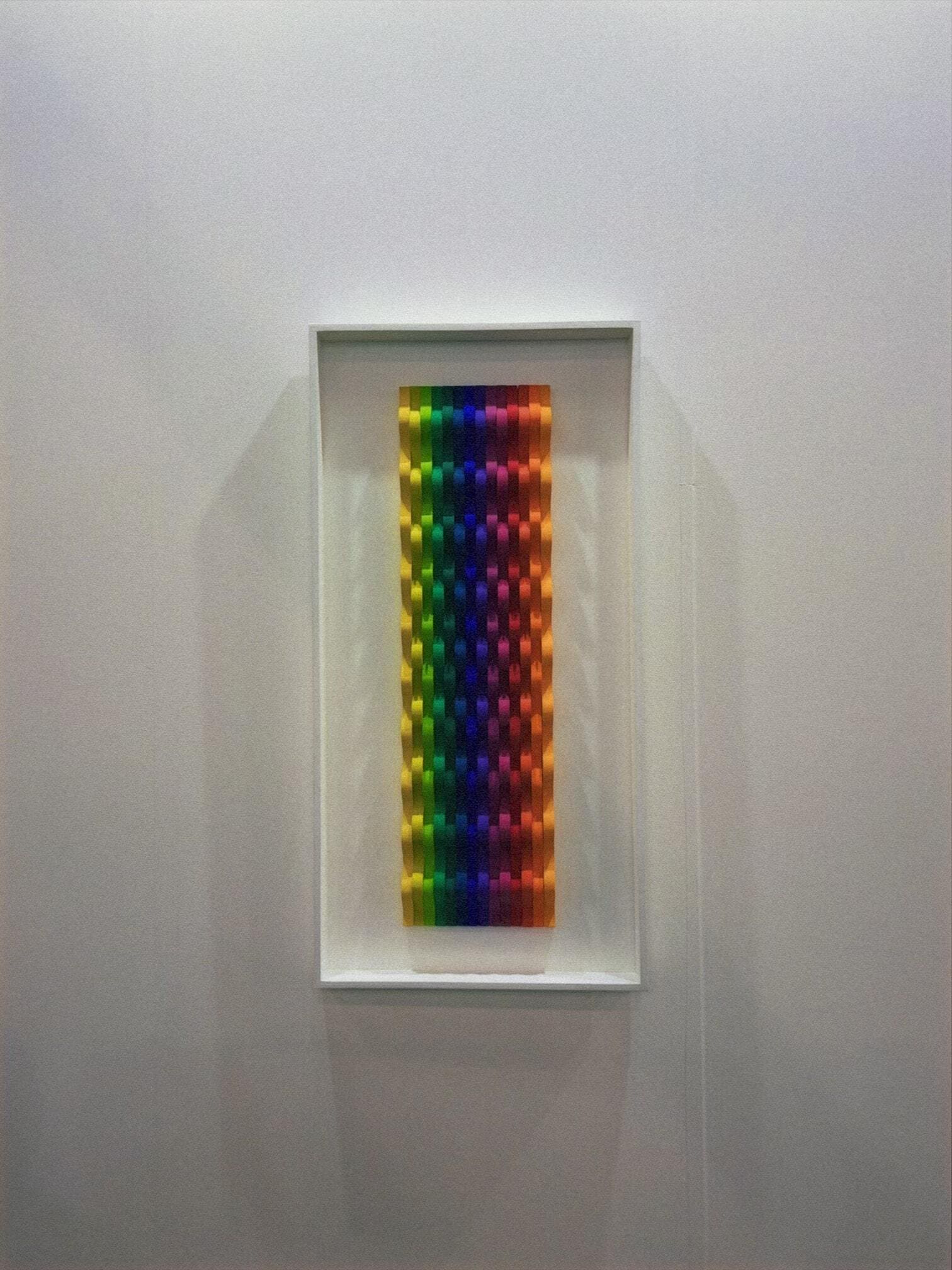 Rainbow holographic art piece in white frame at Zona MACO contemporary art fair