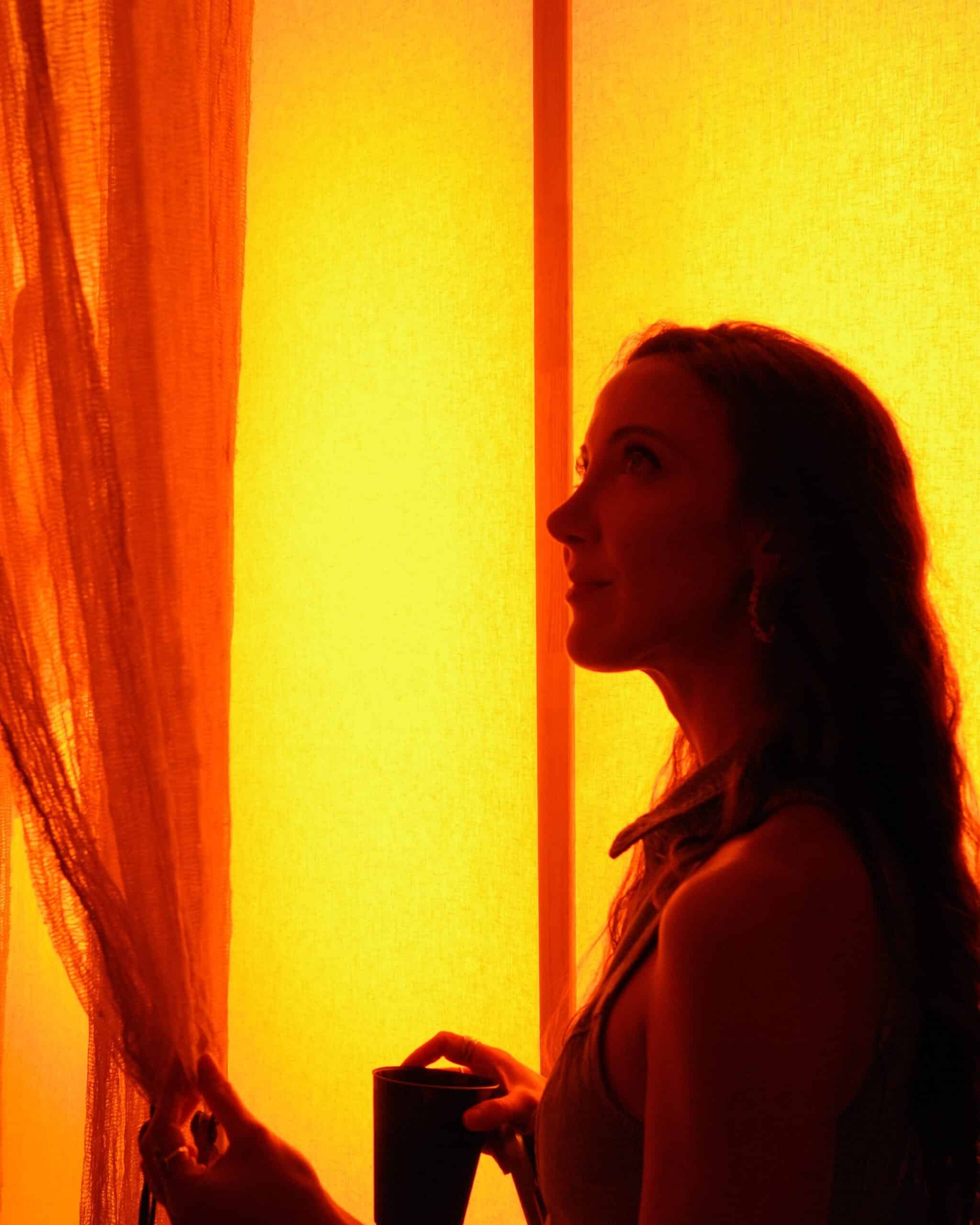 Woman experiencing immersive orange and yellow light art installation at art week Mexico City