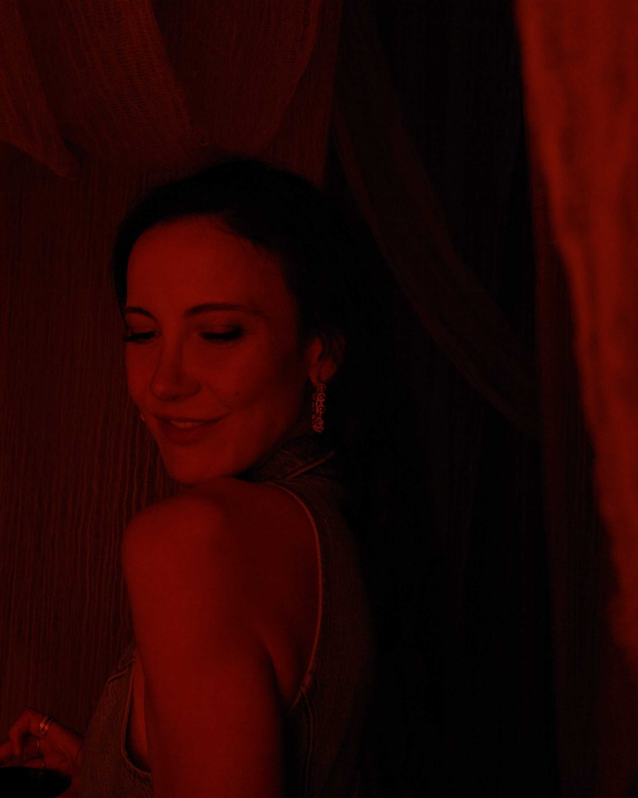 Woman in red lighting at intimate art week Mexico City evening gallery event