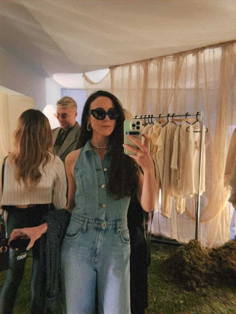 Woman in denim outfit taking mirror selfie at contemporary art gallery during Mexico City art week fashion event