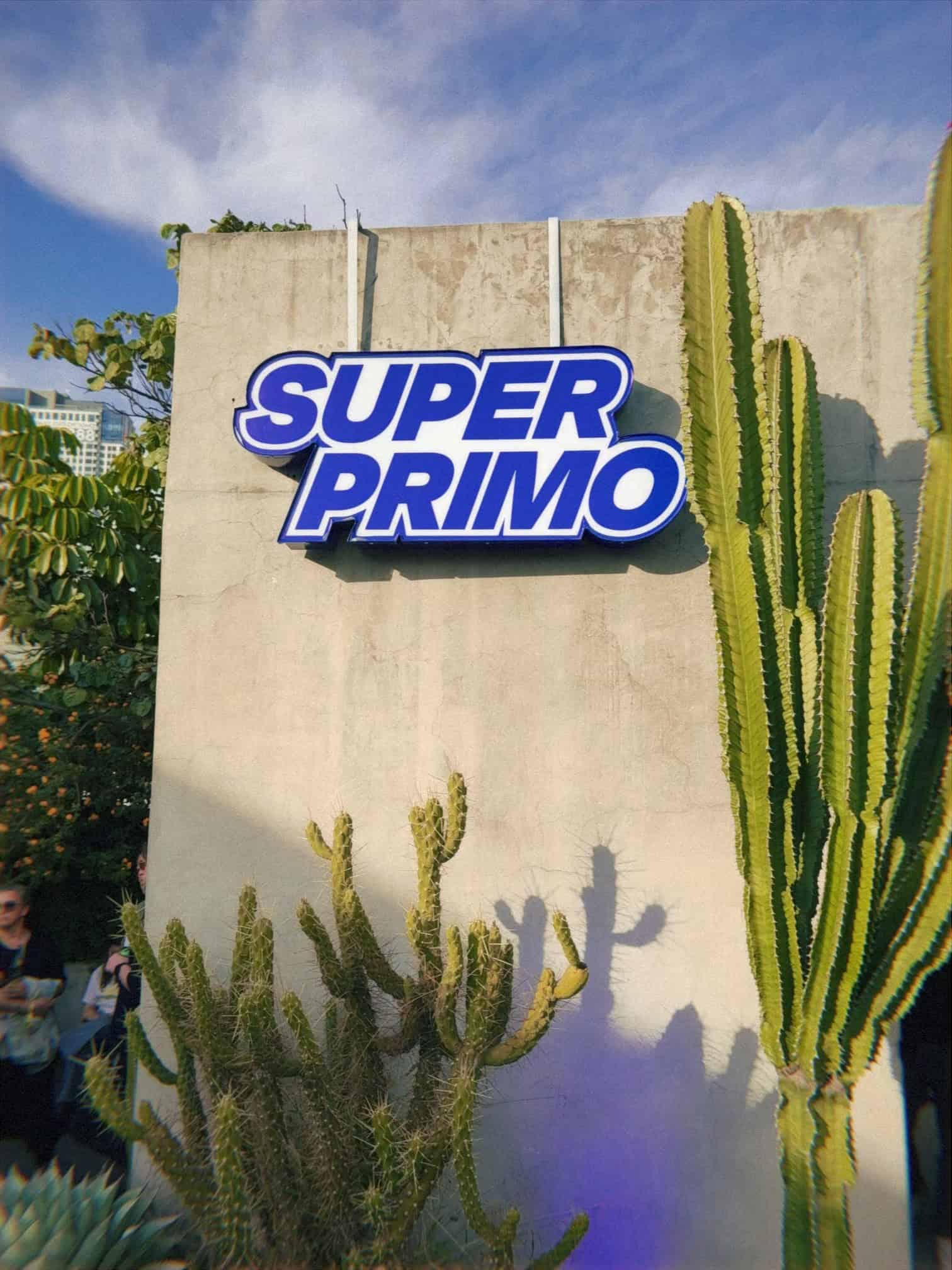 Super Primo sign with tall cacti at outdoor art venue during Mexico City art week