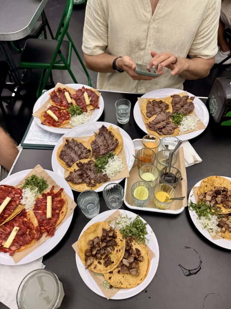 Multiple plates of Mexican tacos with grilled meats at contemporary art Mexico City dining experience