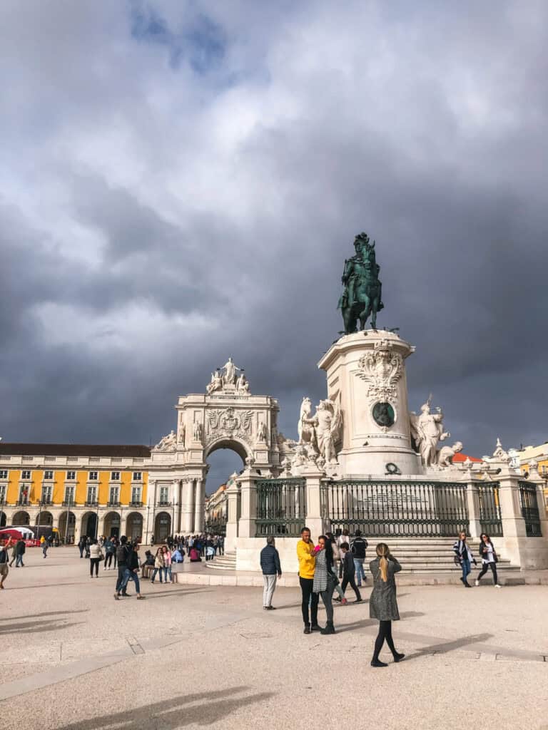 Praça do Comércio in Lisbon with the Arco da Rua Augusta triumphal arch and equestrian statue of King José I under dramatic stormy skies — things to do in Lisbon Portugal