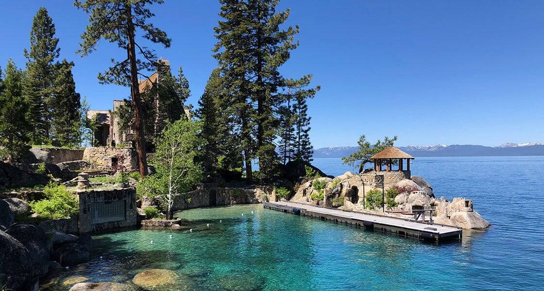 Thunderbird Lodge historic stone estate on Lake Tahoe's east shore with a private dock, gazebo, and crystal-clear green water in the foreground
