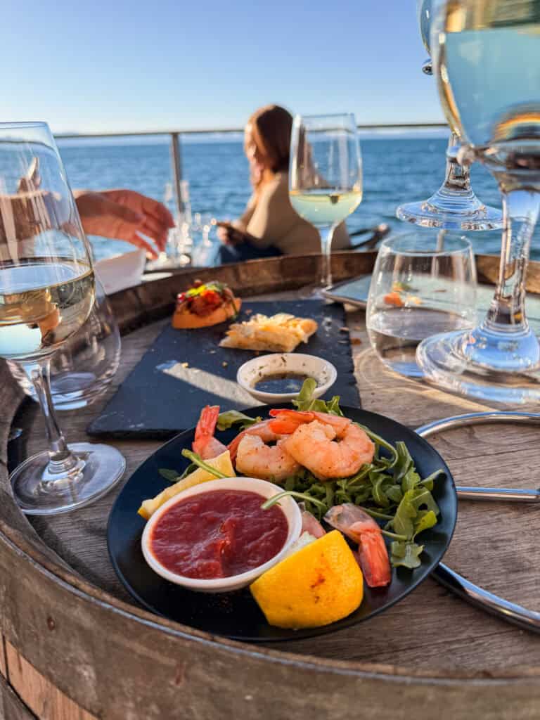Shrimp cocktail and white wine on an outdoor lakeside table at the Idle Hour in South Lake Tahoe