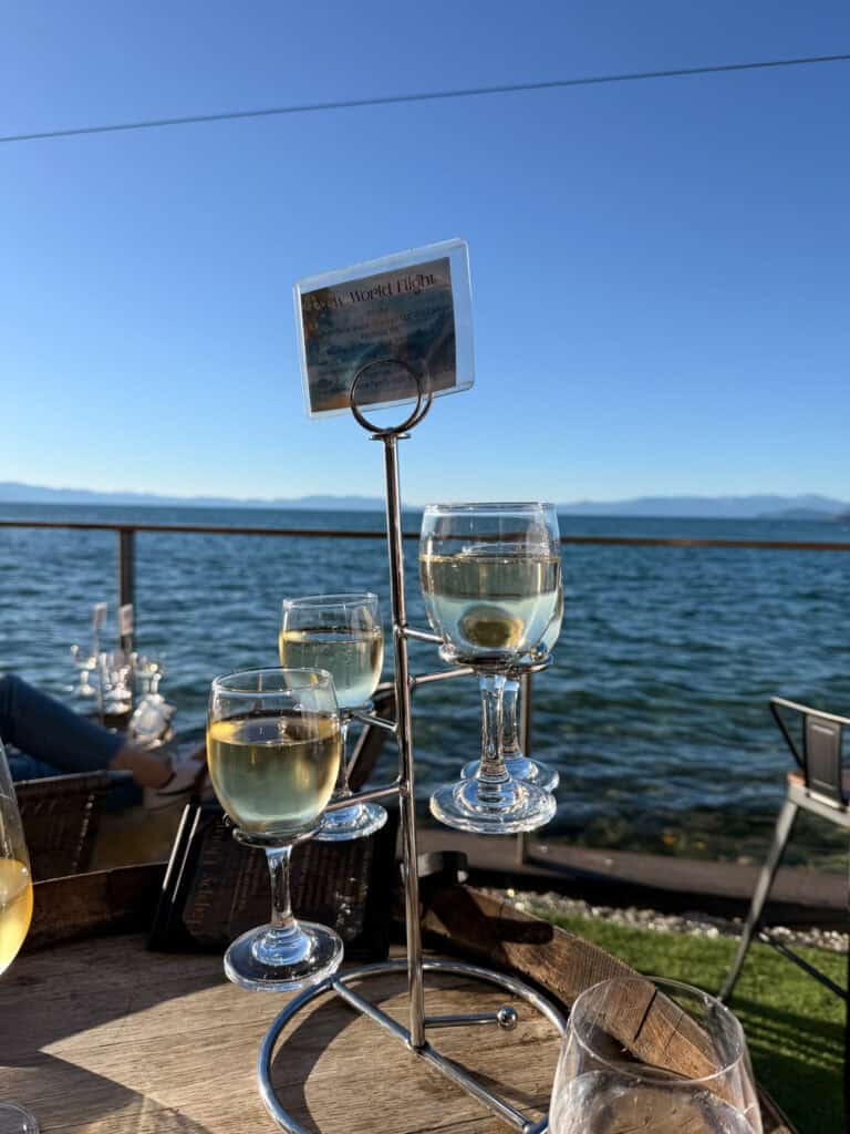 White wine flight on a stand with Lake Tahoe views at the Idle Hour, one of the most scenic South Lake Tahoe restaurants