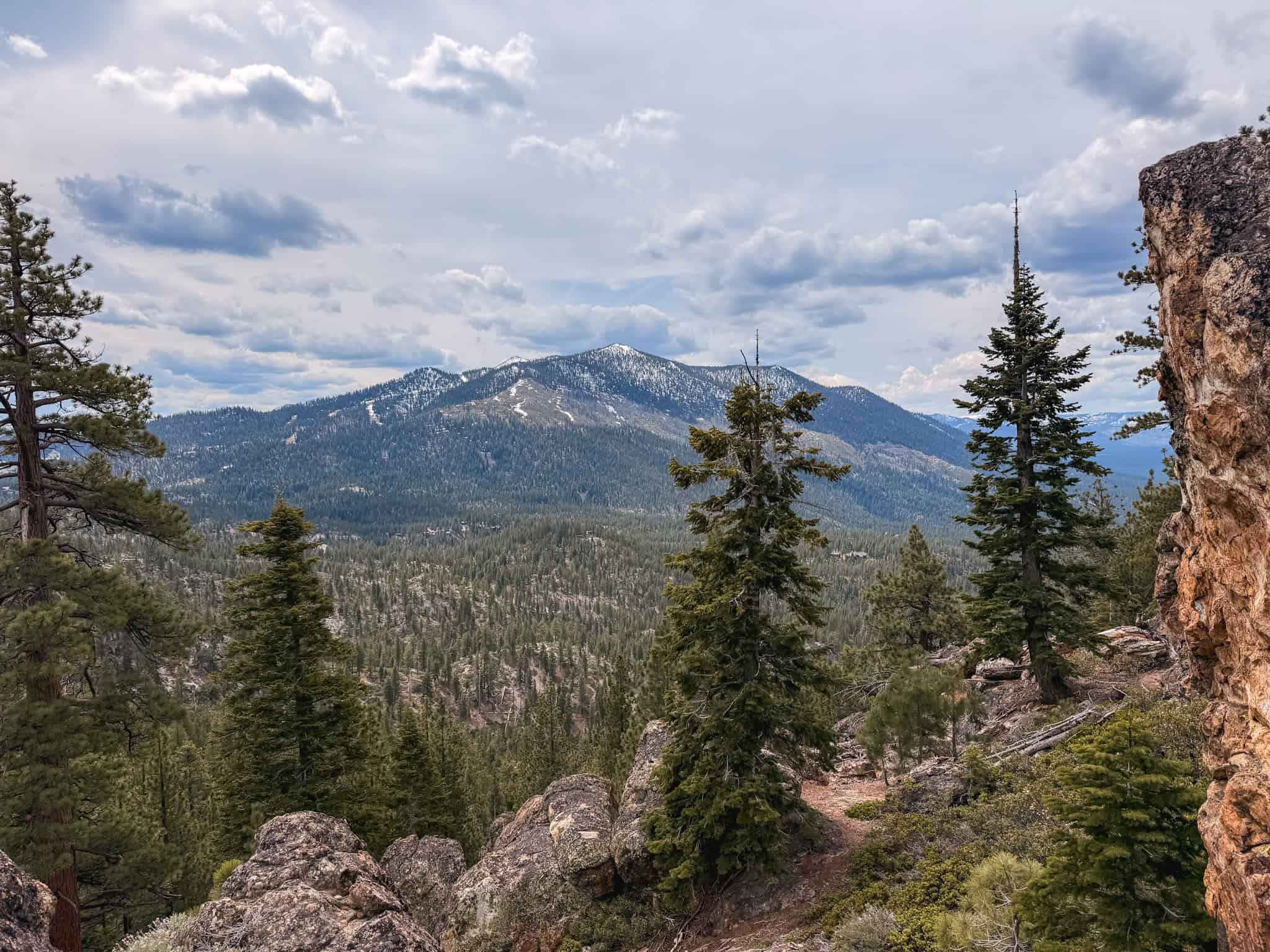 Panoramic view of a snow-dusted mountain peak from the Mount Tallac trail, one of the most challenging lake tahoe hikes with sweeping Sierra Nevada views