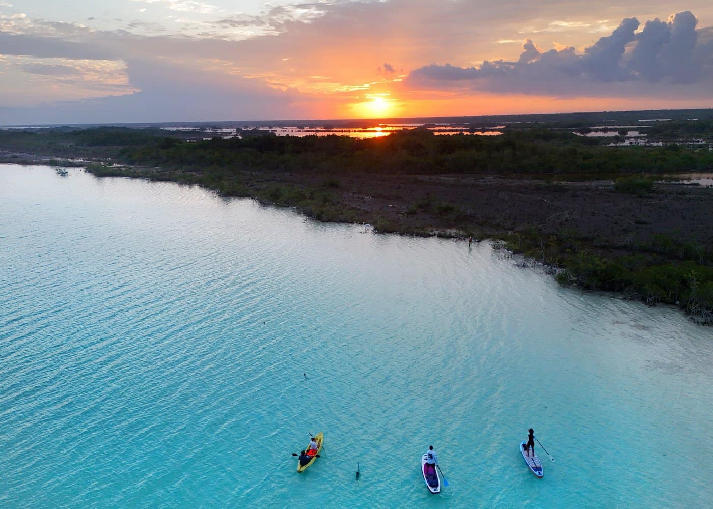  SUP tour over the blue bacalar lagoon with an orange sunrise