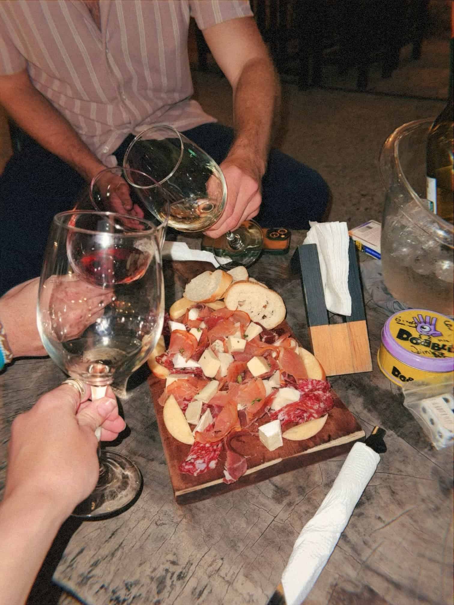 3 wine glasses and a cheese plate with mixed meat