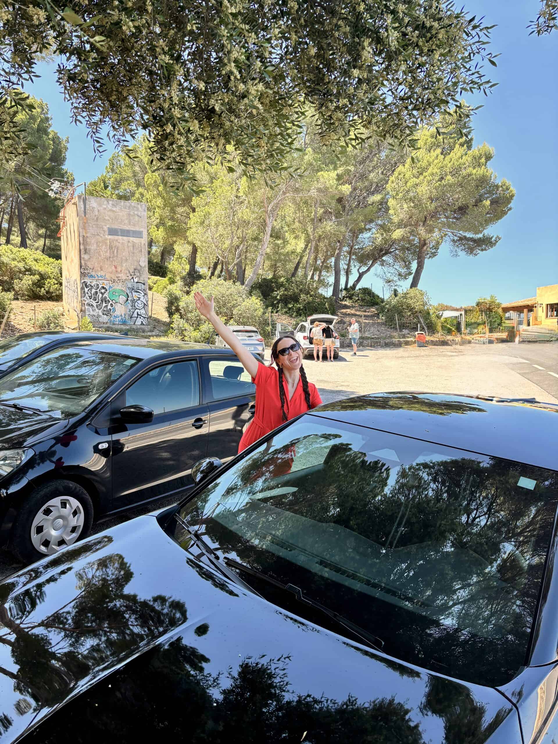 woman in red standing by rental car in Mallorca