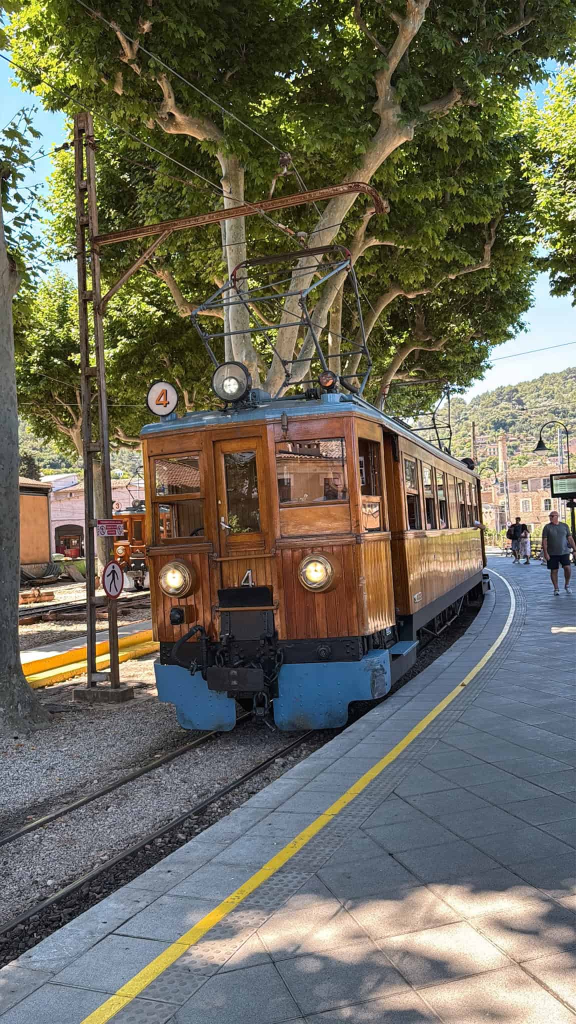 Vintage wooden train arriving at Soller station, a popular day trip from Palma that pairs well with driving in Mallorca.