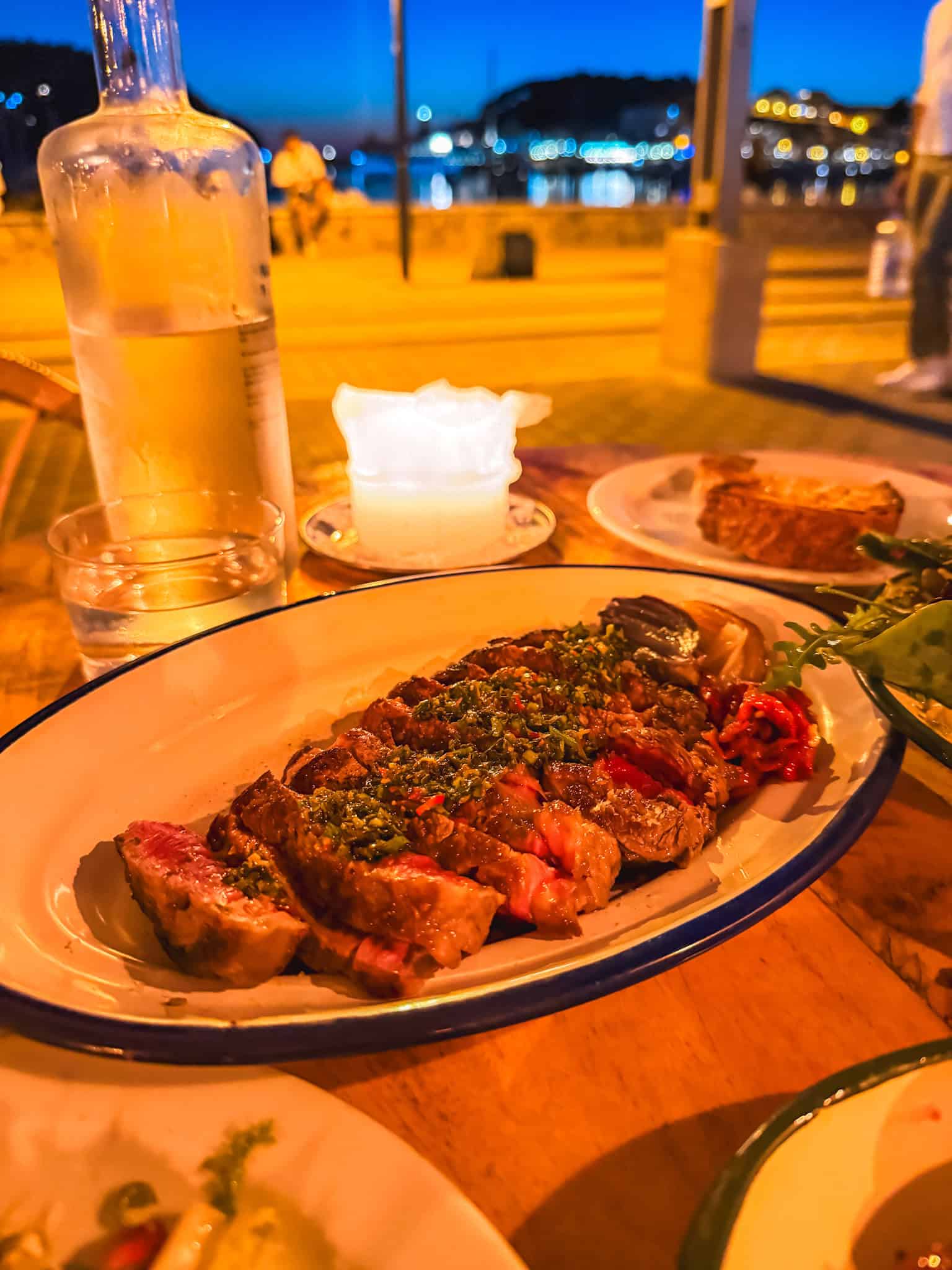 Grilled steak dinner at Blai restaurant overlooking Port de Sóller harbor at night