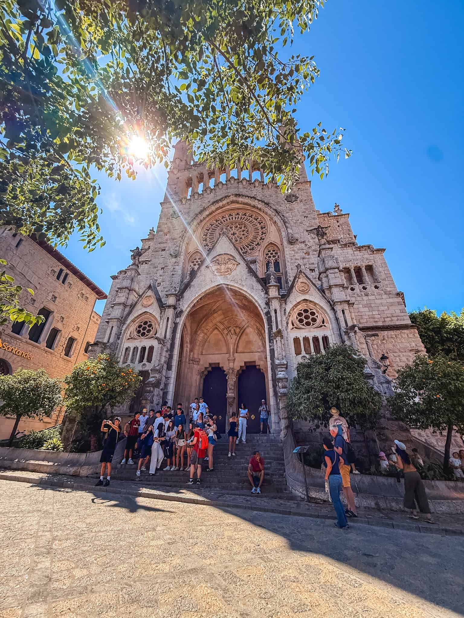 Sant Bartomeu Church in Sóller, Mallorca, with sunshine through the trees