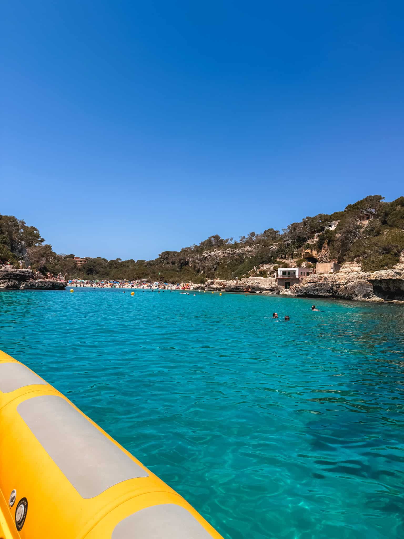 Swimmers and a crowded cove beach seen from the boat, a popular stop on Mallorca boat tours near Cala Mondragó.