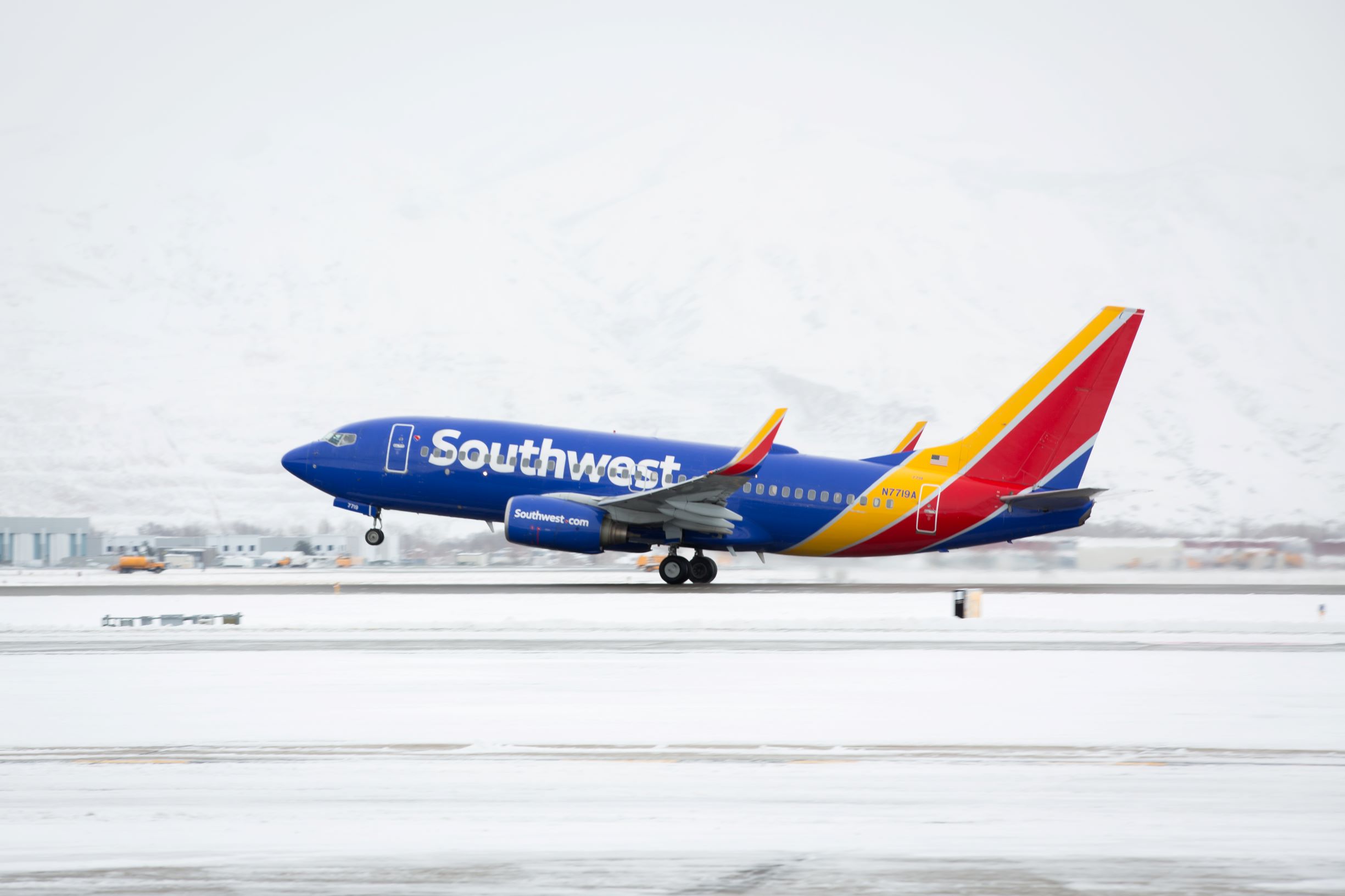 Southwest Airlines Boeing 737 lifting off a snowy runway on a winter flight, the kind of trip a Rapid Rewards companion ticket can cover