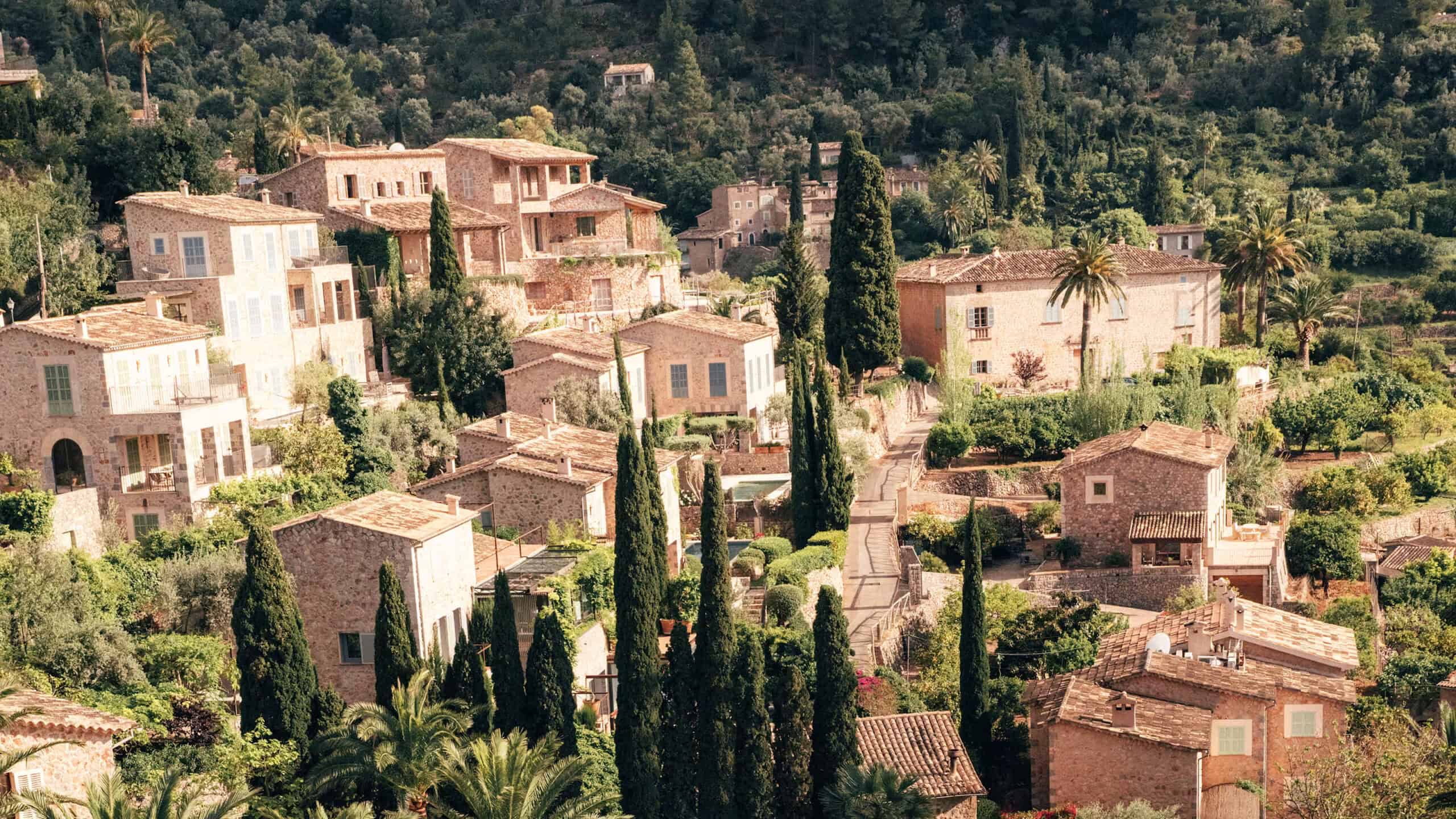 Aerial dusk view of Belmond La Residencia's pool and terraces in the mountains near Deia, a luxury choice for where to stay in Mallorca