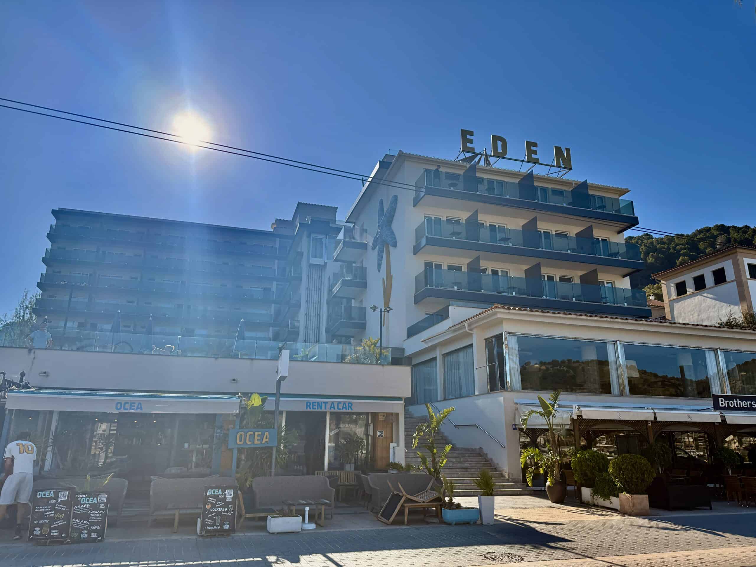 Exterior of Hotel Eden with rooftop bar and beachfront shops in Port de Soller, Mallorca