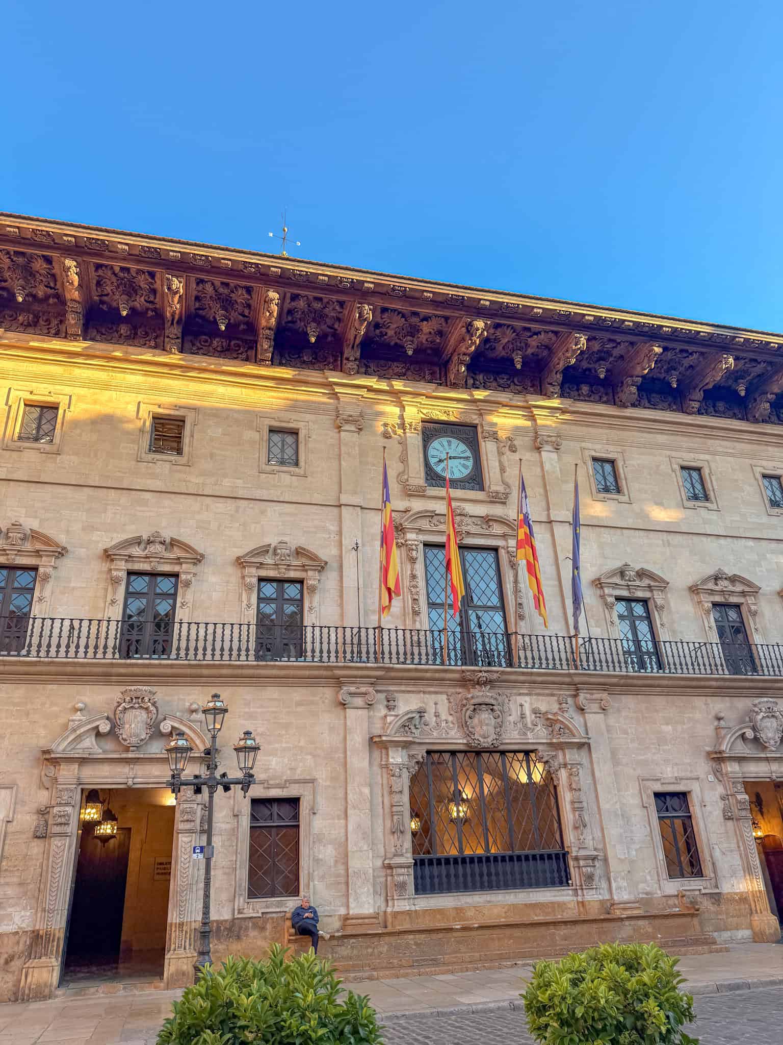 Ornate facade of Palma's historic town hall with carved wood eaves, a landmark near where to stay in Mallorca
